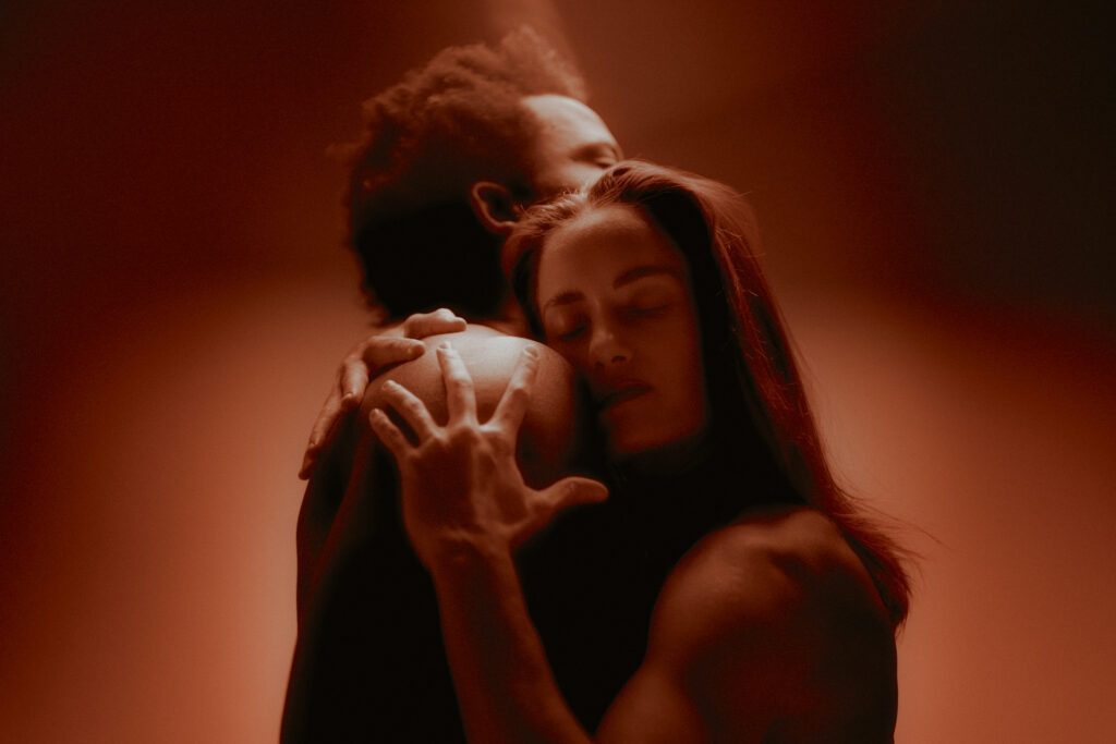 Embracing a man. Red light surronding them.