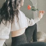 Madison from the side looking at a rose in her hand.