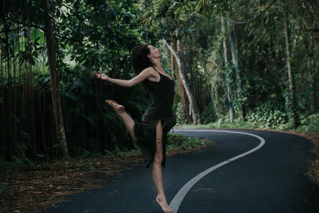 Small country road with Roby Lynn balancing on one leg on the separating line in the middle of the road.
