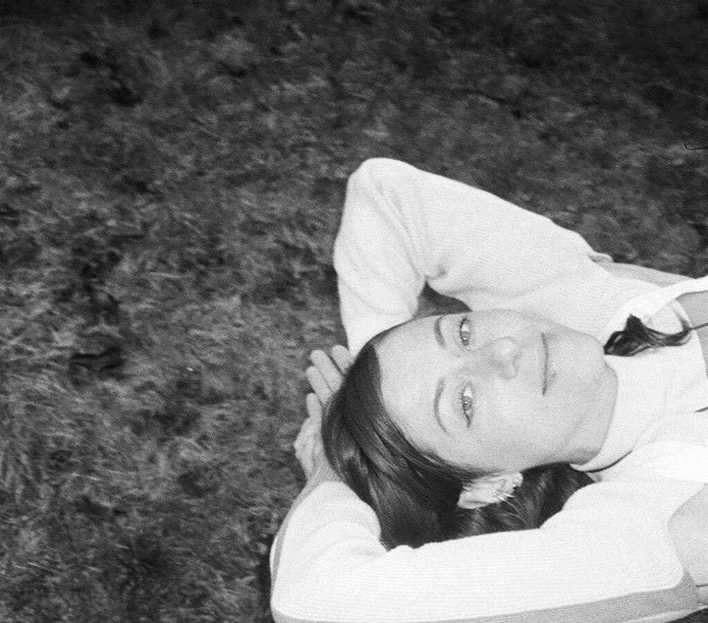 Black and white photo of Roman lying down with a warm smile.