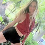 Tropical plants in the backround with Leaira in black shorts
