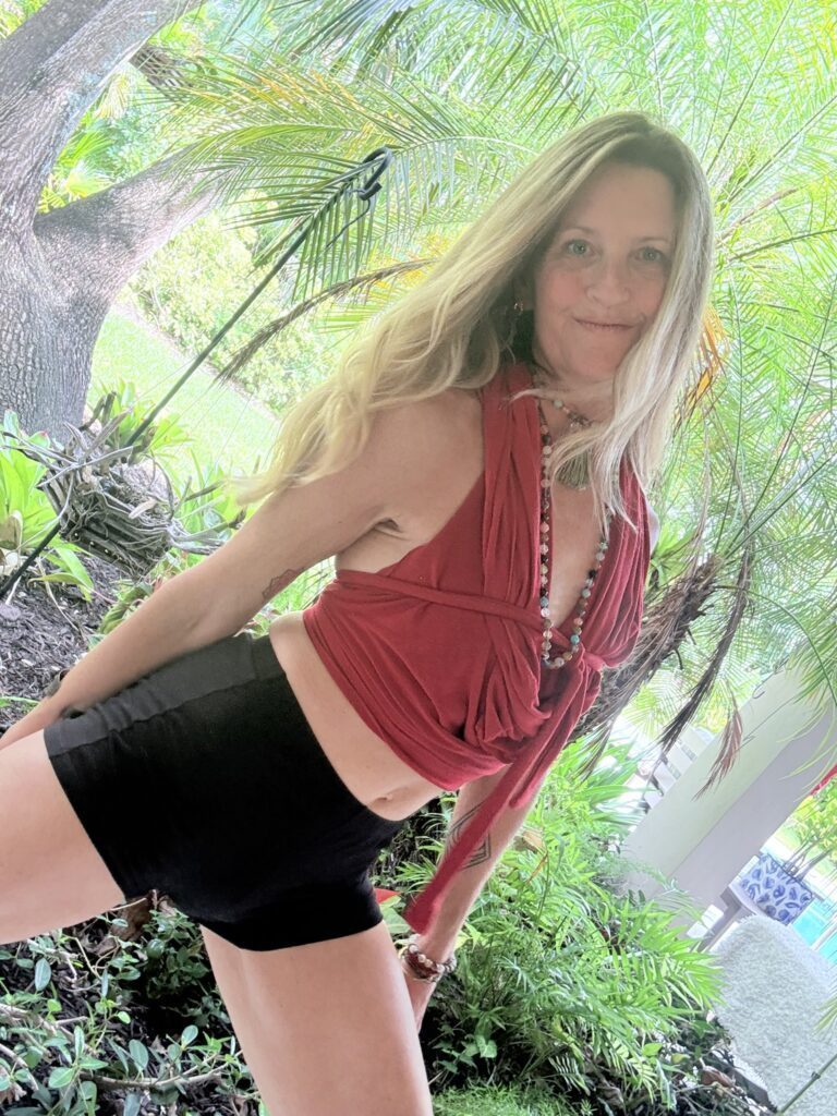 Tropical plants in the backround with Leaira in black shorts