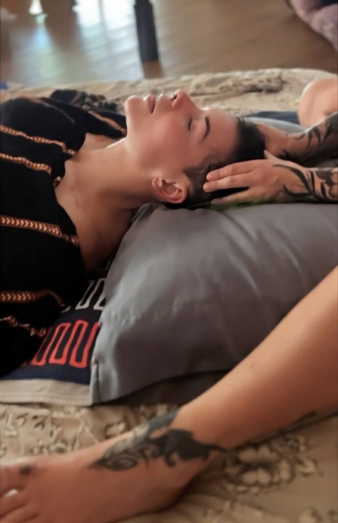 Clients head on a pillow, receiving massage from Andrea.