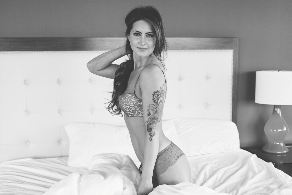 Black & White shot of Andrea on bed in lingerie.
