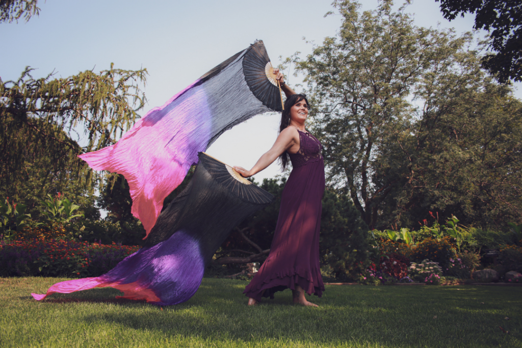 Out in the nature. Aurora Christine is waving a colorful fan-like long flag.