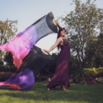 Out in the nature. Aurora Christine is waving a colorful fan-like long flag.