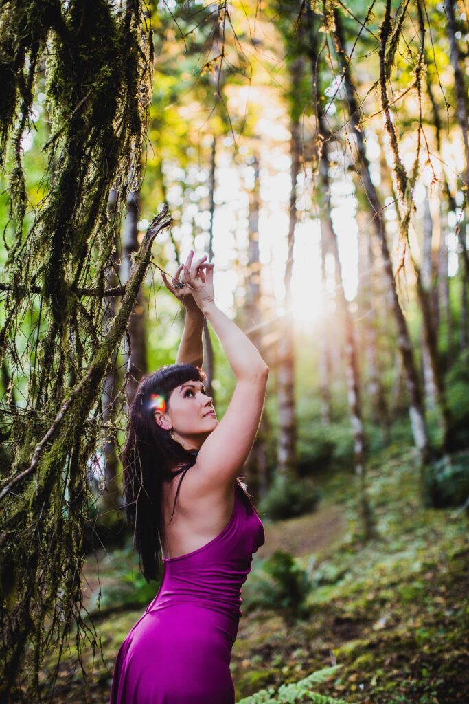 Aurora Christine with a flower in her hair in the woods.
