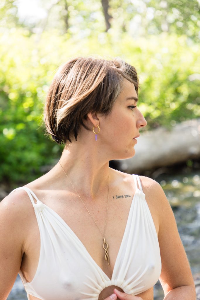 Gaia in a white bra looking to the side.
