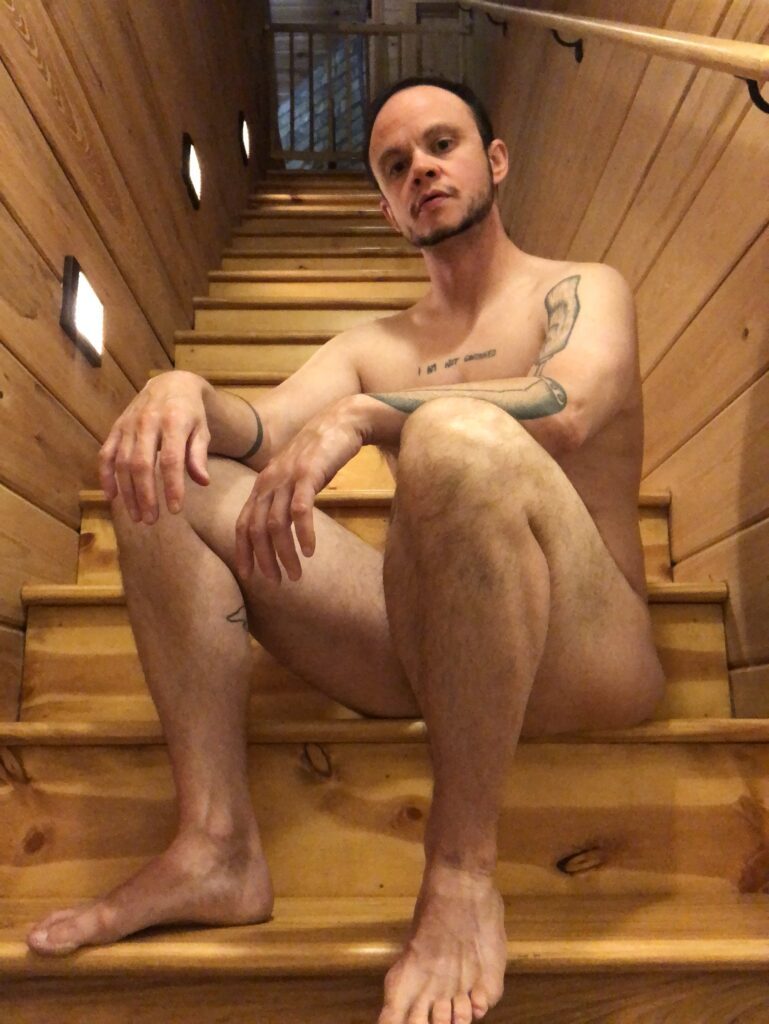 Sitting naked on the stairs.