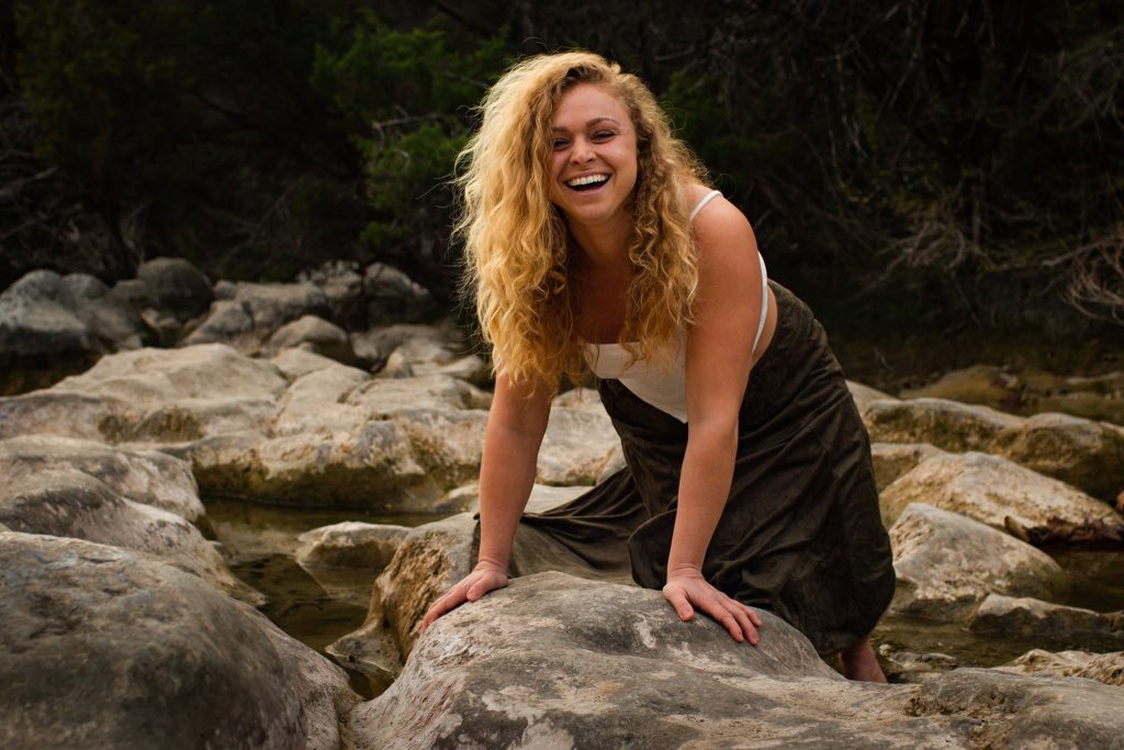 Laughing Gina leaning on a big rock.